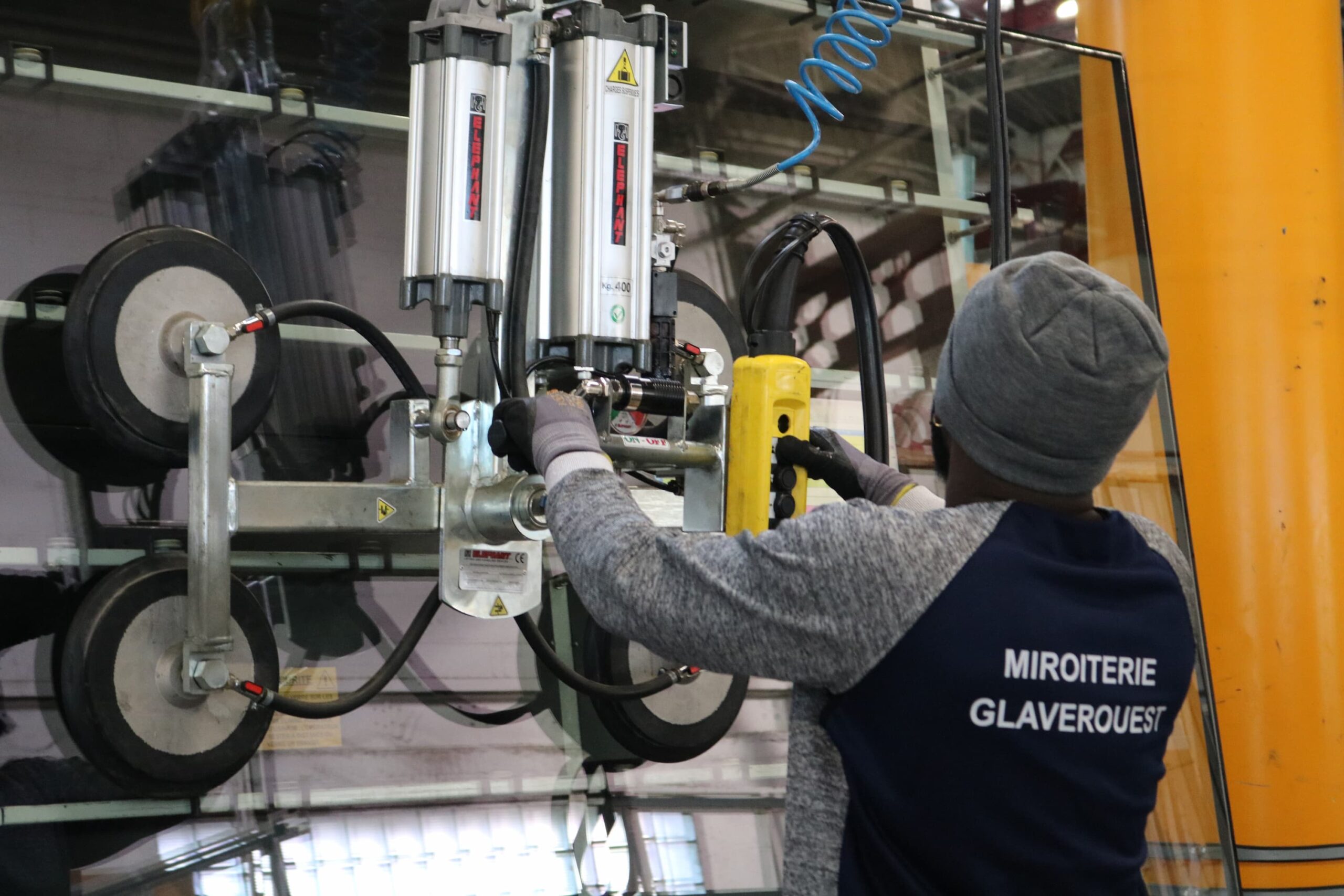 employé de la miroiterie transportant du verre avec un système de ventouse